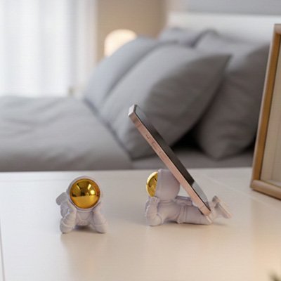 support-téléphone-en-forme-astronaut-sur-la-table-de-chevet